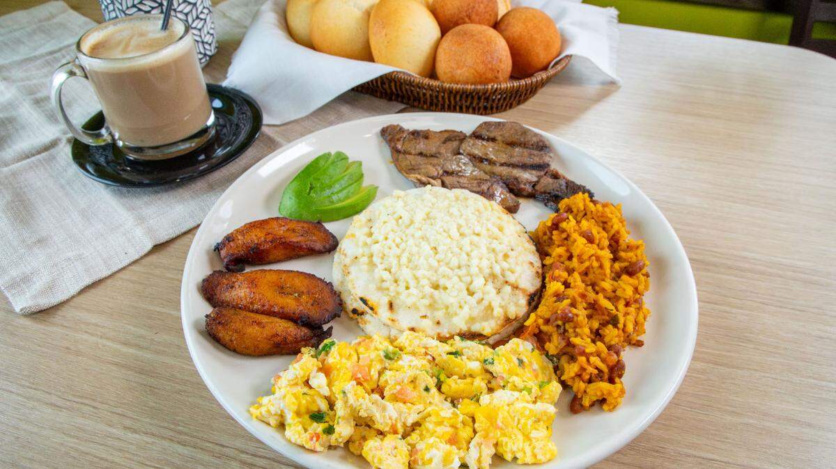 Desayuno Mi Cali, a breakfast dish at Cali Colombian Restaurant, comes with rice mixed with beans, tomato and green onions, grilled meat, egg, a corn cake topped with cheese, sweet plaintains and avocado.