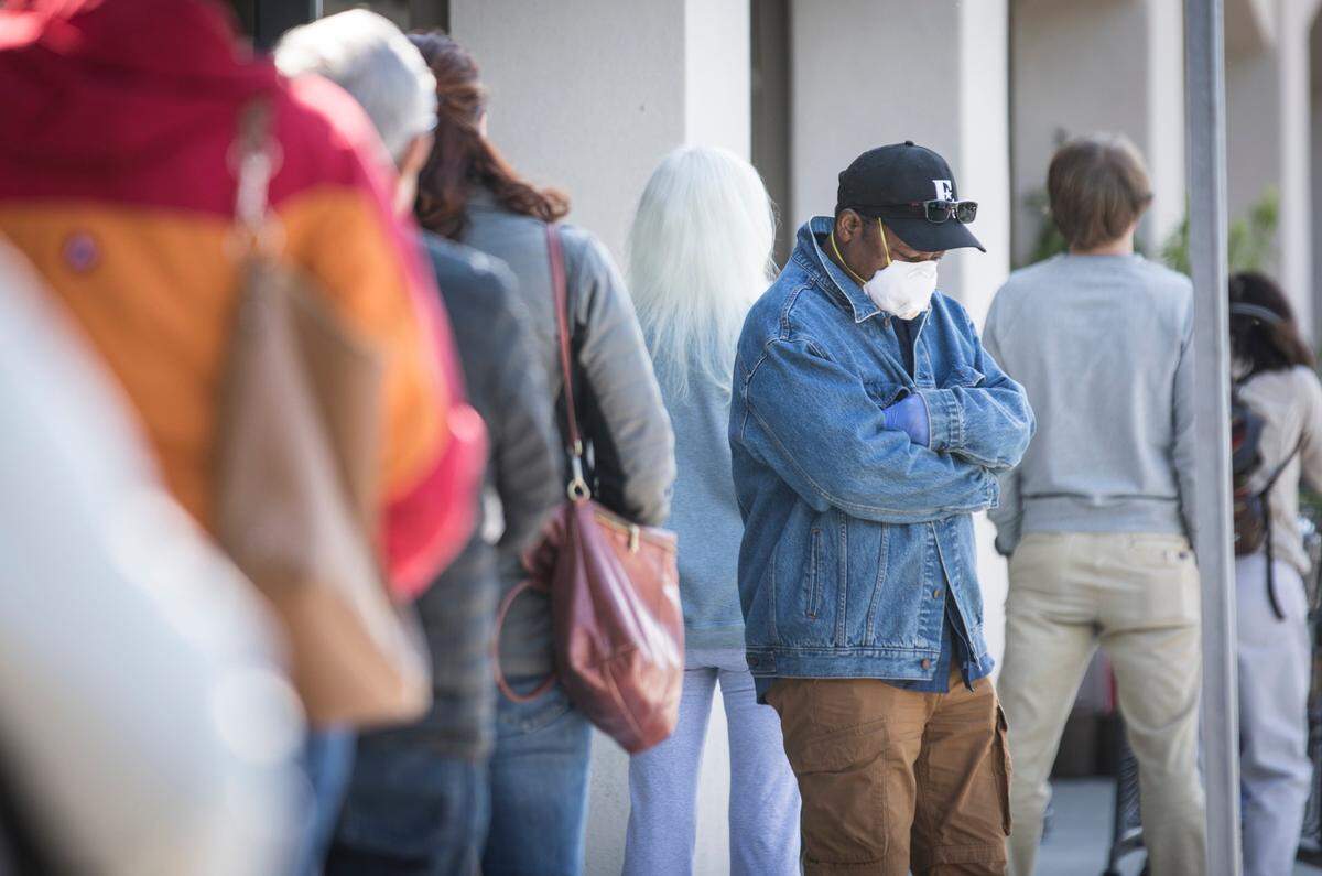 Patrons of the Whole Foods in Chapel Hill, N.C. wait in line at least six feet apart to get inside to shop on Friday, April 10, 2020.