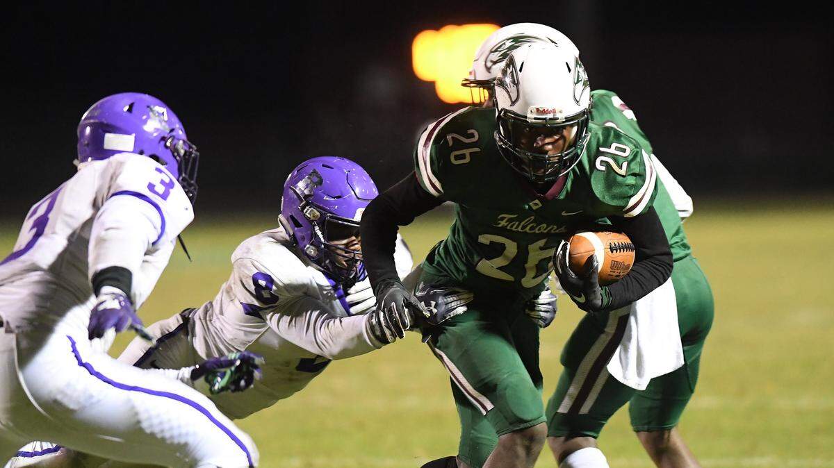 Joshua Hullum (26) of Green Hope carries the ball against Eric Windless (8) and Torey Floyd (3) of Riverside. The Riverside Durham Pirates visited the Green Hope Falcons in a high school football game on November 1, 2019.