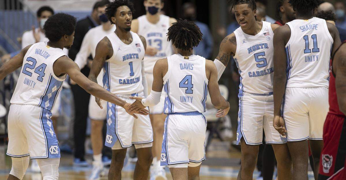 North Carolina’s R.J. Davis (4) is greeted by teammates Kerwin Walton (24) and Armando Bacot (5) after sinking a basket in the second half against N.C. State on Saturday, January 23, 2021 at the Smith Center in Chapel Hill, NC. Davis scored 10 points in the Tar Heels’ victory over N.C. State.