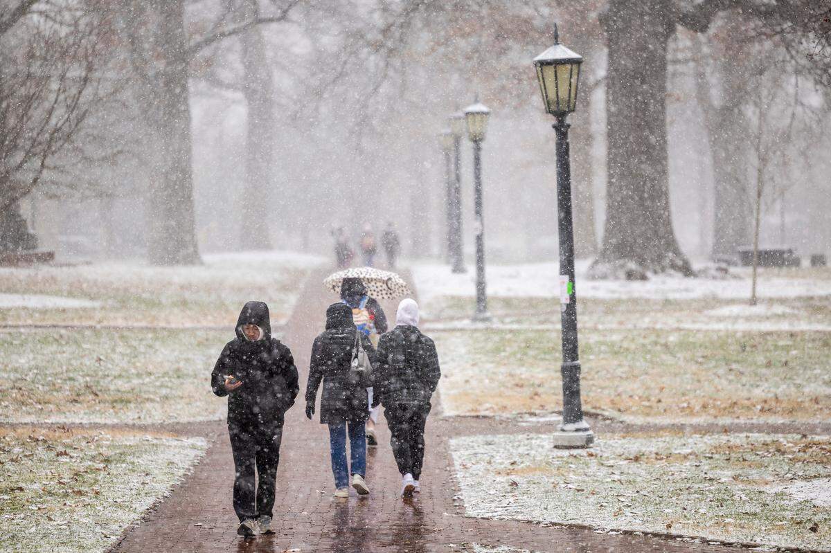 Pedestrians brave the freezing temperature as snow begins to fall at UNC-Chapel Hill on Wednesday, Feb. 19, 2024.