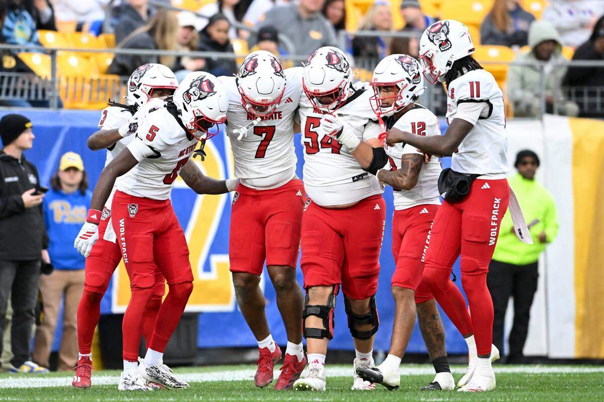 NC State’s Justin Joly (7) s helped off the field by teammates after being injured scoring a 59-yard touchdown during the second quarter against the Pittsburgh Panthers at Acrisure Stadium on Oct. 25, 2025 in Pittsburgh.