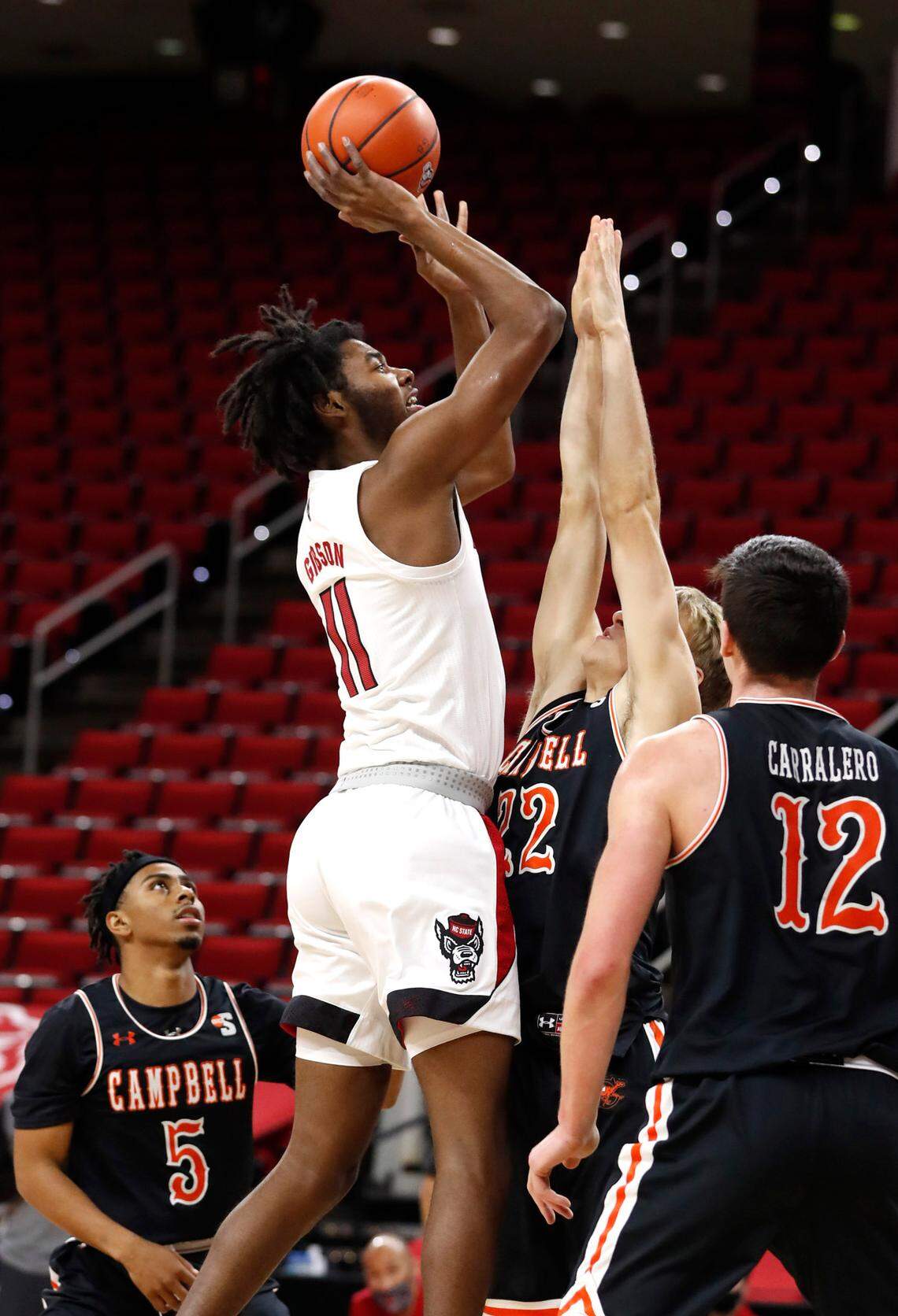 N.C. State’s Jaylon Gibson (11) shoots as Campbell’s Laurynas Vaitaras (22) defends during the second half of N.C. State’s 69-50 victory over Campbell at PNC Arena in Raleigh, N.C., Saturday, Dec. 19, 2020.