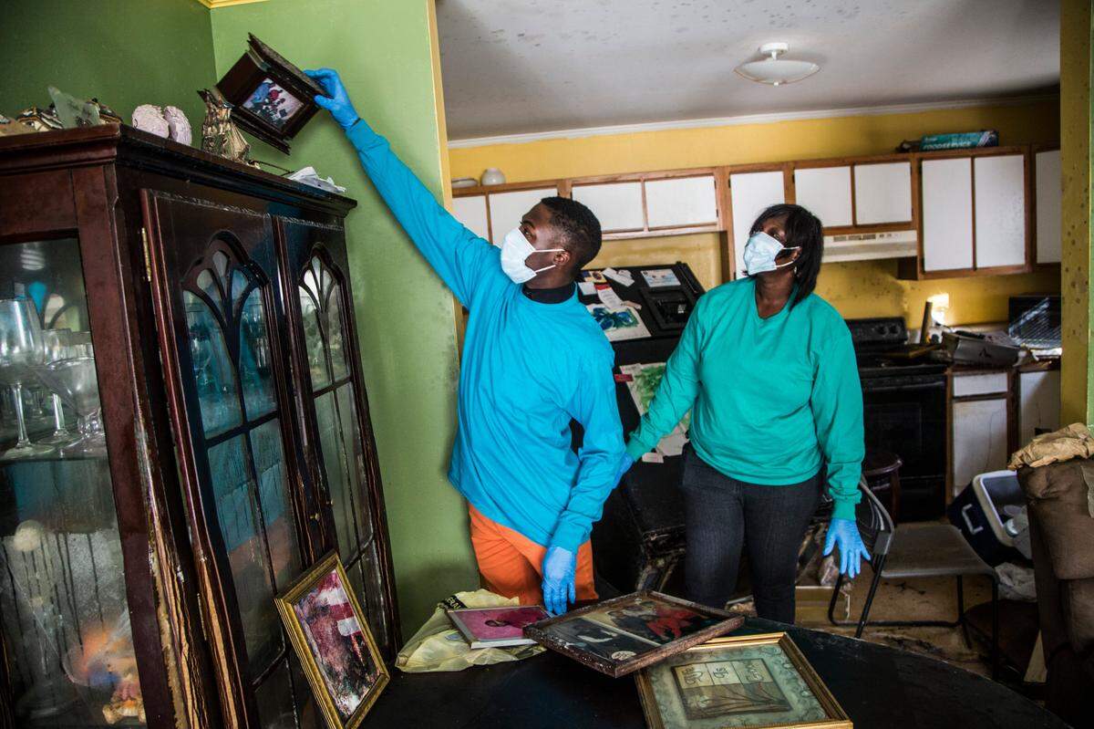 Justin Williams and his mother Theresa Williams find a family photo while assessing damage and salvaging belongings with Tuesday, October 25, 2016 at their home in Princeville, NC. Tuesday afternoon was the first opportunity in more than two weeks that Princeville residents were allowed to return to their homes since flooding associated with Hurricane Matthew forced residents to evacuate.