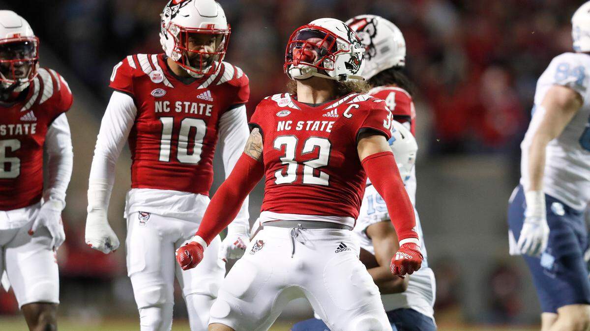 N.C. State linebacker Drake Thomas (32) celebrates after stopping North Carolina running back Ty Chandler (19) during the first half of N.C. State’s game against UNC at Carter-Finley Stadium in Raleigh, N.C., Friday, November 26, 2021.