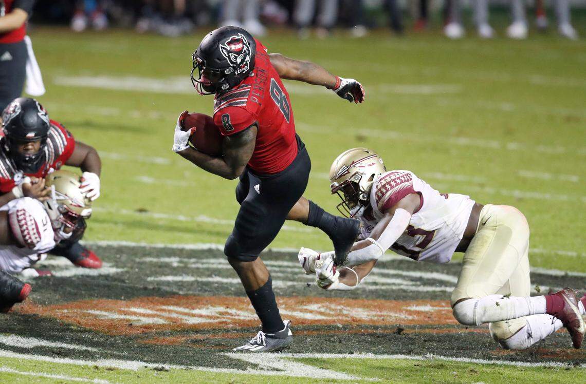 N.C. State running back Ricky Person Jr. (8) tries to escape from Florida State linebacker Amari Gainer (33) during the first half of N.C. State’s game against Florida State at Carter-Finley Stadium in Raleigh, N.C., Saturday, Nov. 14, 2020.