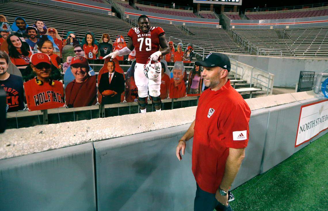 N.C. State offensive tackle Ikem Ekwonu (79) laughs with head coach Dave Doeren after he found the cutout of Doeren after N.C. State’s 45-42 victory over Wake Forest at Carter-Finley Stadium in Raleigh, N.C, Saturday, Sept. 19, 2020.