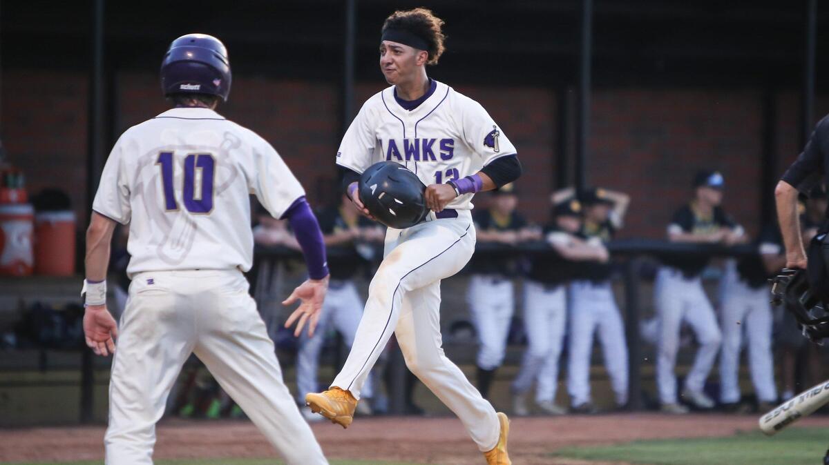 Holly Springs’ Trevor Sheehan (13) celebrates as he crosses home plate just after teammate Patrick Trease (10) to tie the game at 3-3 during Corinth Holders’ playoff baseball game at Holly Springs on Thursday, May 23, 2019. Holly Springs won the game 5-3.