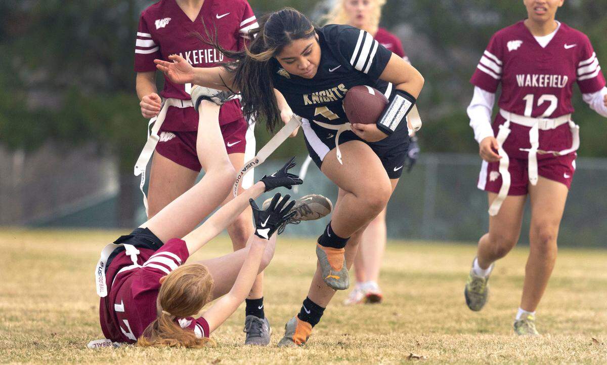 Knightdale High School’s Amy Gomez (14) gets by Wakefield 17 during a flag football scrimmage at Heritage High School in Wake Forest, N.C., Wednesday, Jan. 24, 2024.