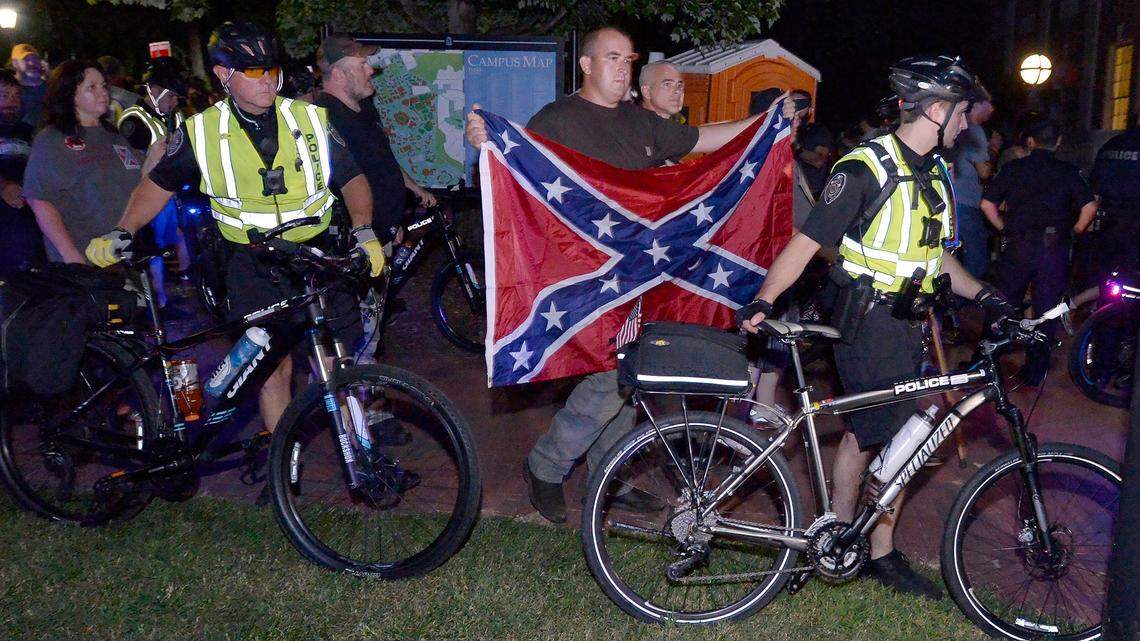 Members of ACTBAC are escorted away from the Silent Sam memorial site to their vehicles in the Morehead Planetarium parking lot on the campus of UNC-Chapel Hill, Thursday, August 30, 2018 during a rally to commemorate the Confederate statue.