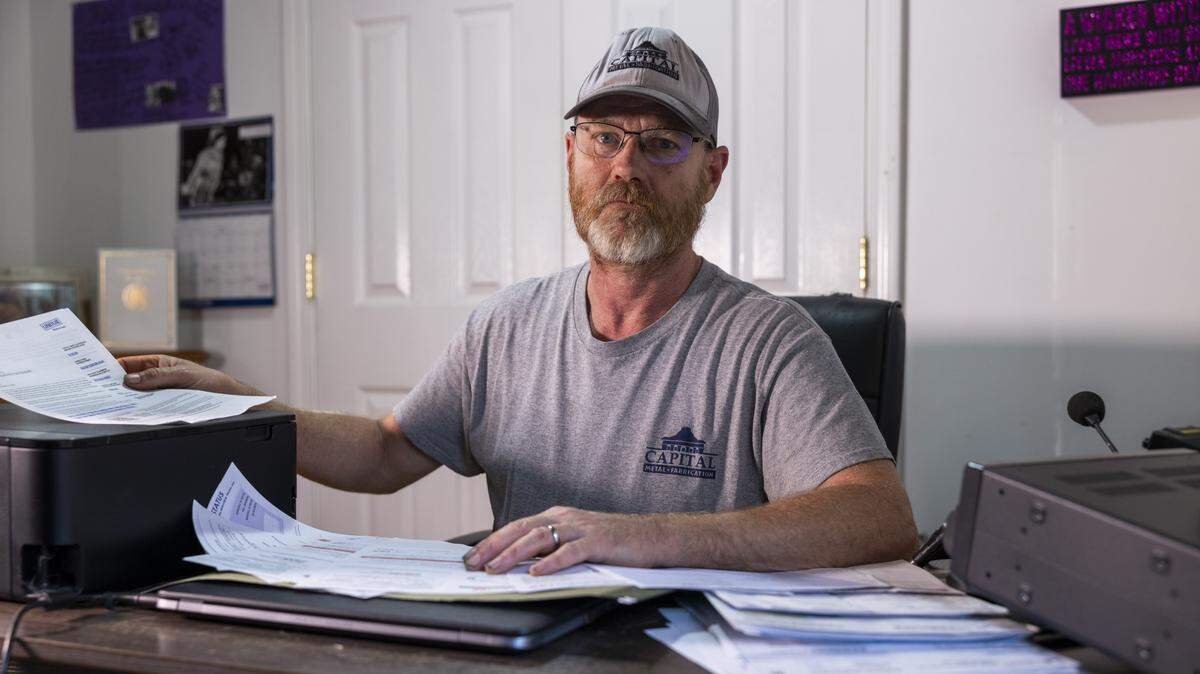 Randall Edge, 54, looks over medical bills at his home in Raleigh on Thursday, Nov. 13, 2025. Edge, an HVAC technician and the sole earner for a family of four, recently had about $1,800 in anesthesia charges from a 2022 colonoscopy erased through North Carolina’s medical debt relief program. He has since received another anesthesia bill of more than $1,000 for the same preventive procedure this year, a newer debt that likely will not qualify for relief.