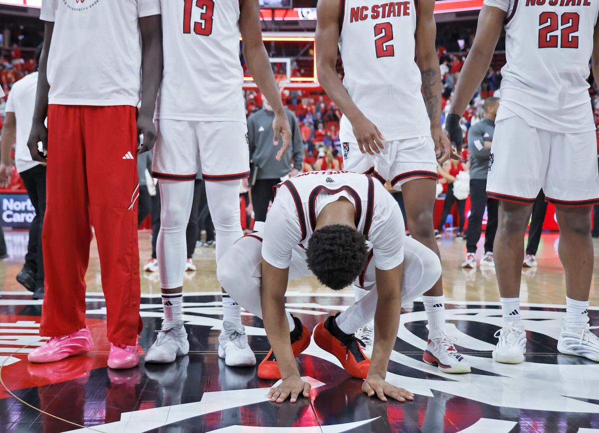 N.C. State’s Quadir Copeland bows his head as his team gathers at center court following the Wolfpack’s 77-76 overtime loss to Kansas on Saturday, Dec. 13, 2025, at Lenovo Center in Raleigh, N.C.