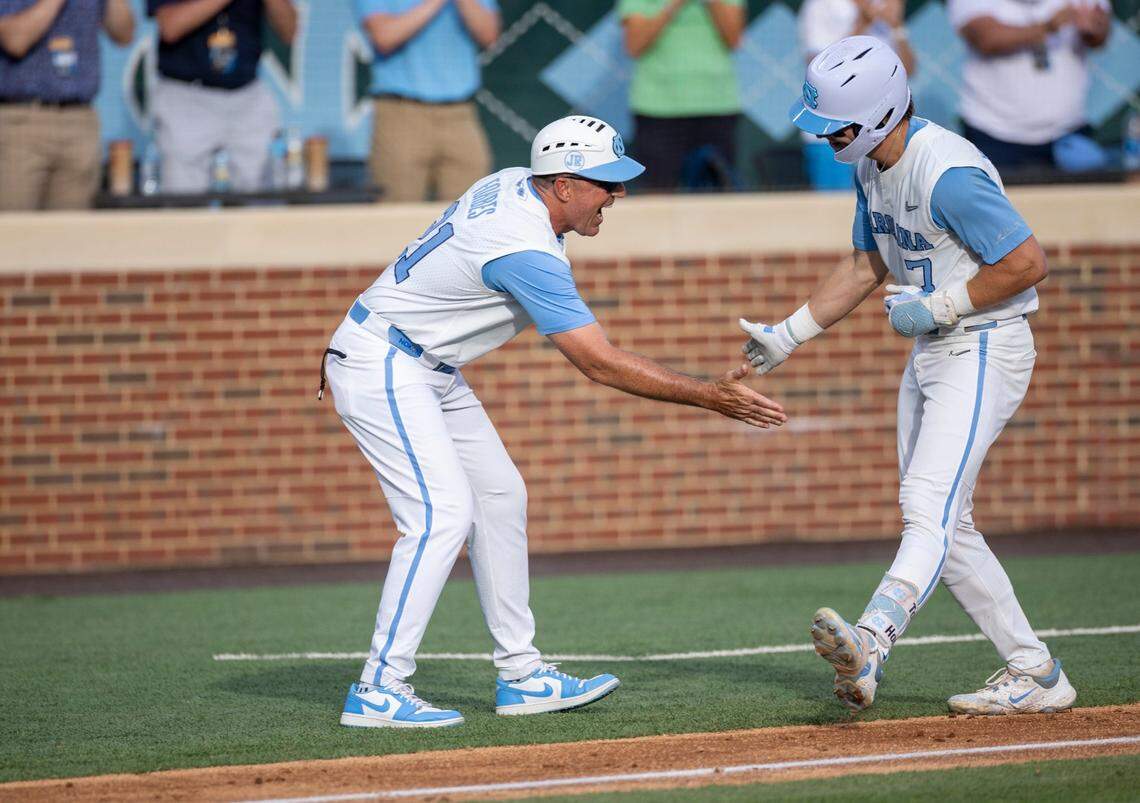 North Carolina coach Scott Forbes greets Vance Honeycutt (7) as he rounds third base after connecting for a 3 RBI home run in the fifth inning to give the Tar Heels a 3-0 lead against LSU during the NCAA Regional on Saturday, June 1, 2024 at Boshamer Stadium in Chapel Hill, N.C.