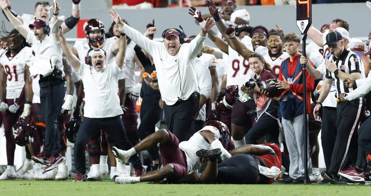 The Virginia Tech sideline erupts after N.C. State tight end Justin Joly (7) can’t pull in the reception on fourth down with 45 seconds left in the game during Virginia Tech’s 23-21 victory over N.C. State at Carter-Finley Stadium in Raleigh, N.C., Saturday, Sept. 27, 2025.