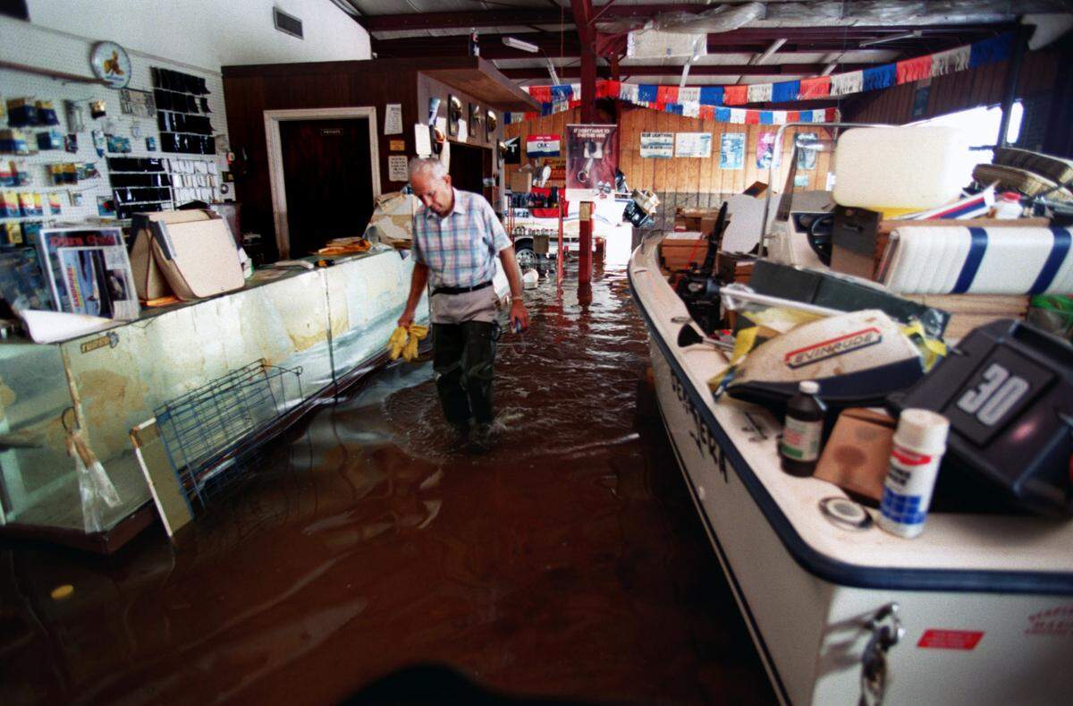 With years of life’s work ruined by Hurricane Floyd floodwaters, Lionel Stapleford tries to salvage what he can of his boat store on Hwy. A70 By-Pass near the Neuse River in Kinston.