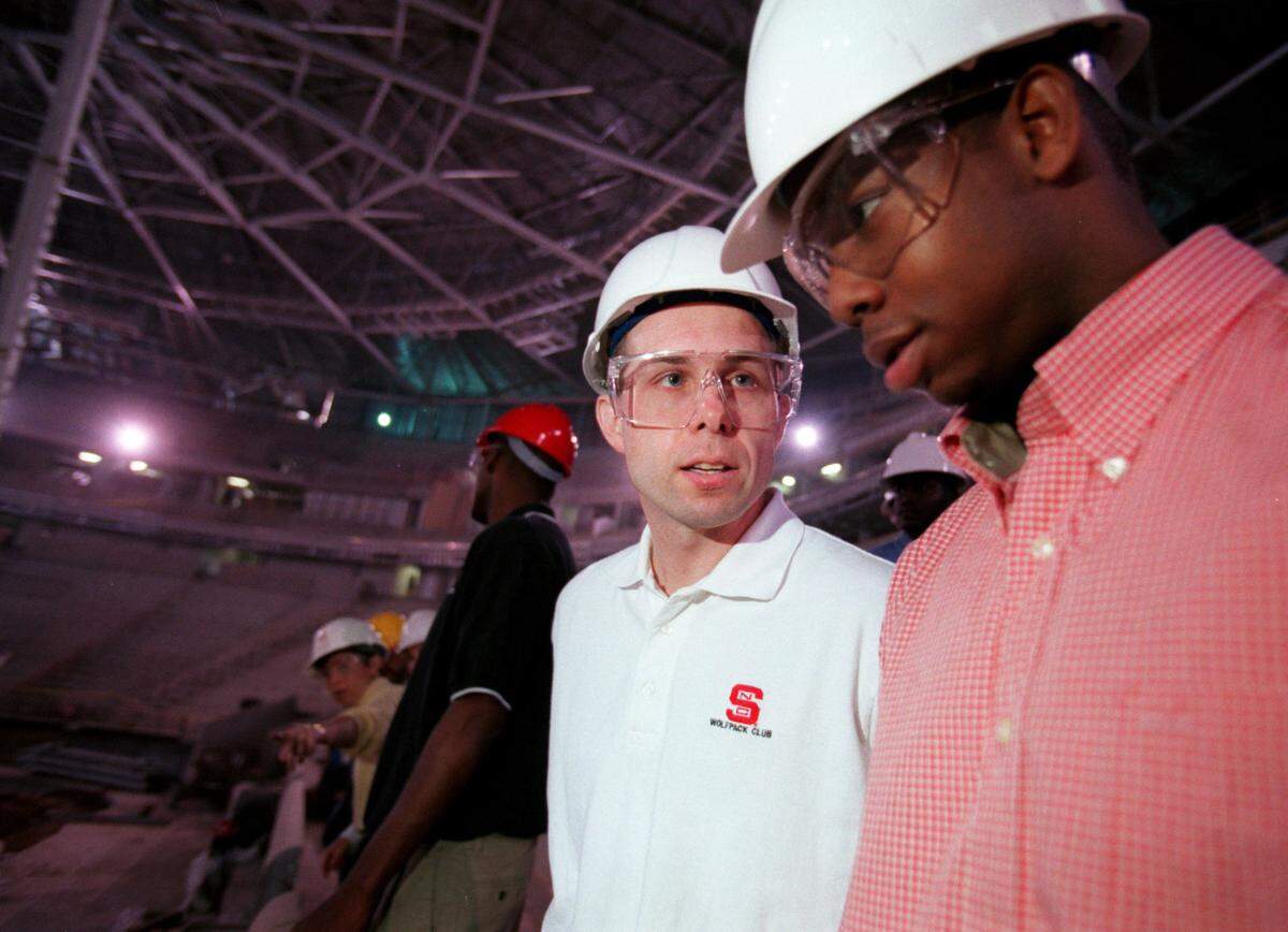 N.C. State coach Herb Sendek discusses the court of the new arena with senior Justin Gainey as the two take a tour of the ESA.