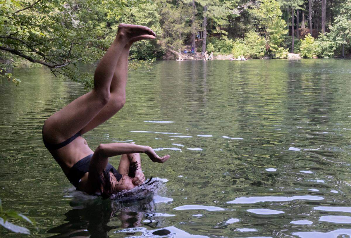 Kristine Williams does a backflip into the water at the Eno Rock Quarry on Saturday, July 15, 2023, in Durham, N.C.