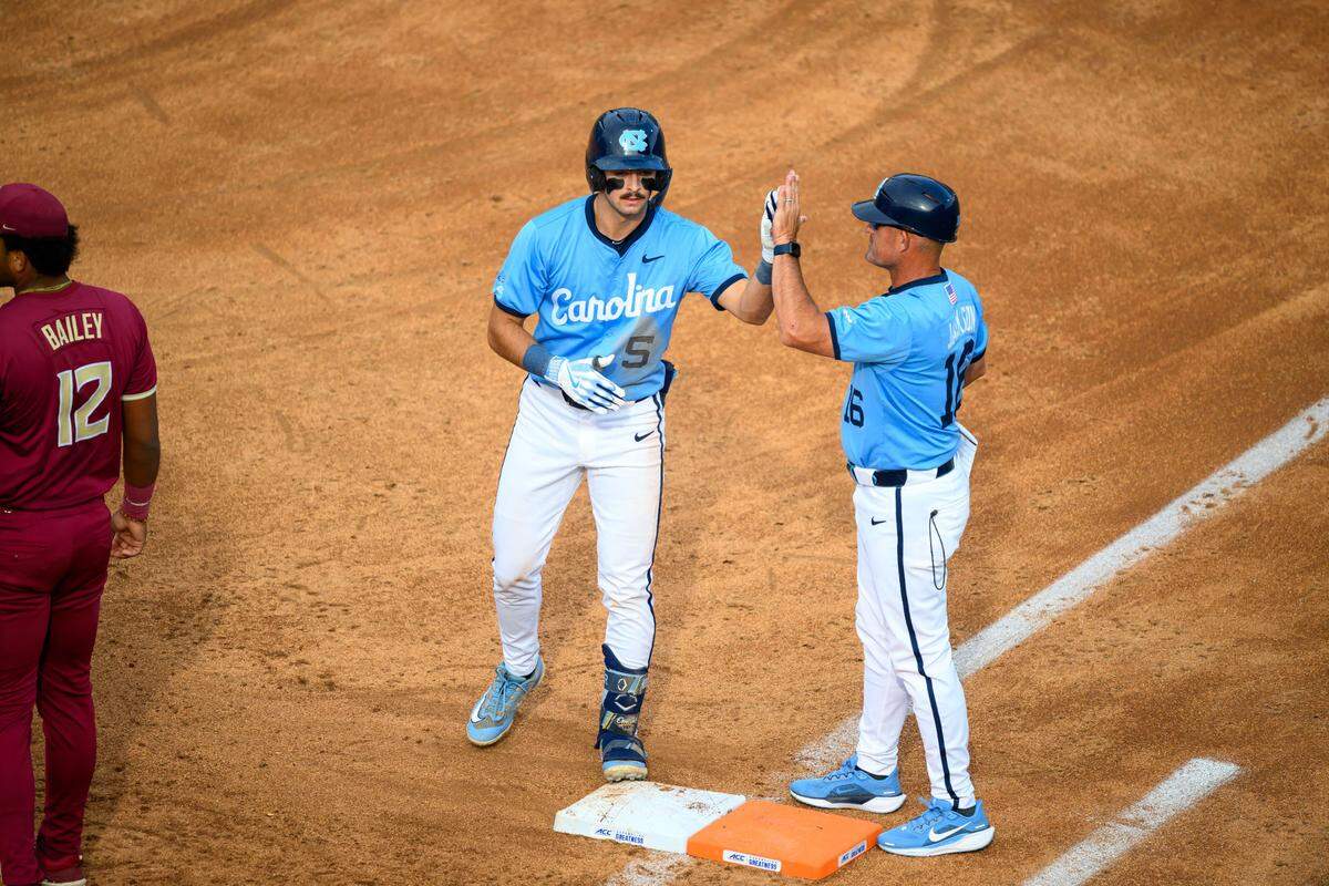UNC’s Gavin Gallaher (5) high fives assistant coach Scott Jackson during the Tar Heels’ 7-5 win over Florida State in the ACC Tournament semifinal on Saturday, May 24, 2025, at Durham Bulls Athletic Park in Durham, N.C.