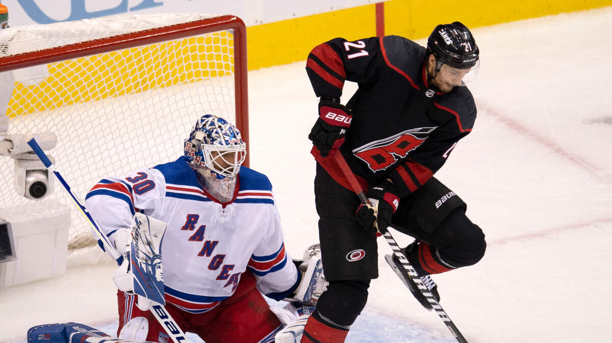 Carolina Hurricanes right wing Nino Niederreiter (21) deflects the puck as New York Rangers goaltender Henrik Lundqvist (30) defends during the first period in the NHL hockey Stanley Cup playoffs in Toronto, Saturday, Aug. 1, 2020. (Frank Gunn/The Canadian Press via AP)