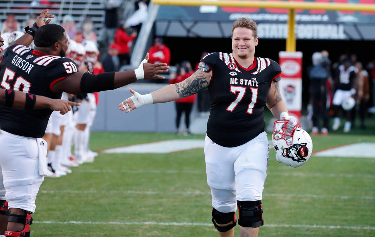 N.C. State guard Joe Sculthorpe (71) greats teammates as he is acknowledged on senior day before N.C. State’s game against Georgia Tech at Carter-Finley Stadium in Raleigh, N.C., Saturday, Dec. 5, 2020.