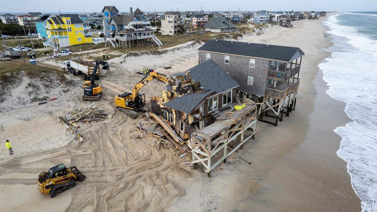 A demolition crew tears down a beach home Wednesday, Nov. 15, 2023, in Rodanthe. The National Park Service recently purchased two homes in Rodanthe as part of a pilot program to buy erosion-threatened properties and remove them before Mother Nature does.