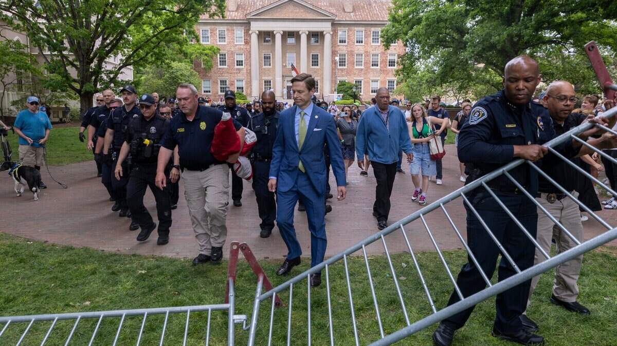 Interim Chancellor Lee Roberts and police prepare to rehang an American flag after it was brought down by demonstrators and replaced with a Palestinian flag Tuesday, April 30, 2024 at UNC-Chapel Hill. About 1000 pro-Palestinian demonstrators rallied after a “Gaza solidarity encampment” was removed by police early Tuesday morning.