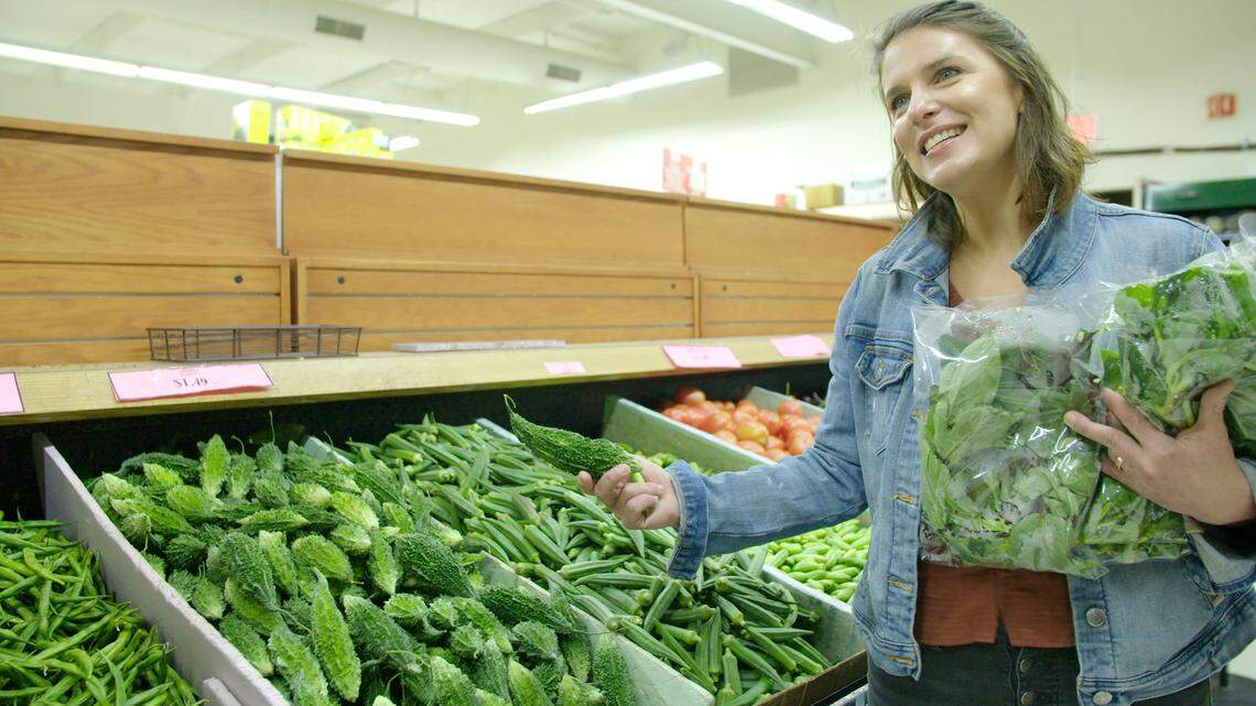 Vivian Howard holds up a bitter melon while shopping at an Indian grocery store in Cary. Her new PBS series, South by Somewhere, documents the foods of a changing south.