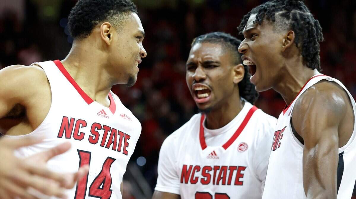 N.C. State’s Terquavion Smith (0) and Greg Gantt (23) celebrate with Casey Morsell (14) after Morsell made the basket while being fouled during the first half of N.C. State’s game against FSU at PNC Arena in Raleigh, N.C., Wednesday, Feb. 1, 2023.