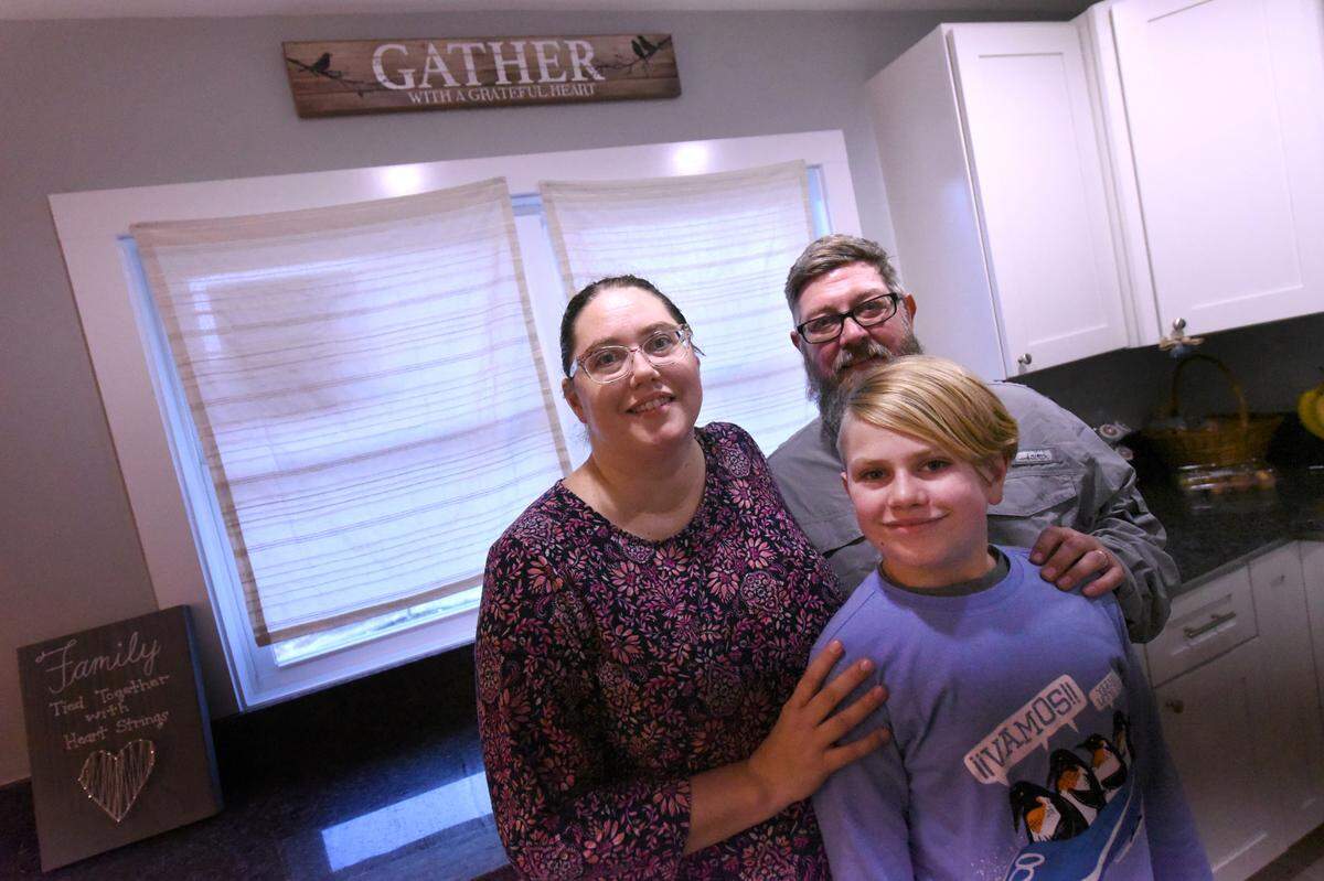 Michael and Amy Riggs and their son Mason stand in their home were an oak tree fell on their home and displaced them from their home for 14 and a half months. The renovation of the home was just finished recently and allowed the Riggs family to finally move back in.