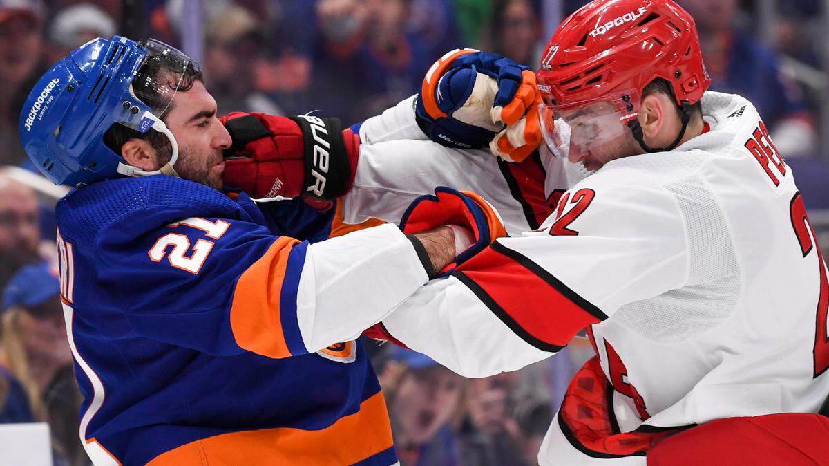 New York Islanders center Kyle Palmieri (21) and Carolina Hurricanes defenseman Brett Pesce (22) fight during the second period in game three of the first round of the 2023 Stanley Cup Playoffs at UBS Arena.