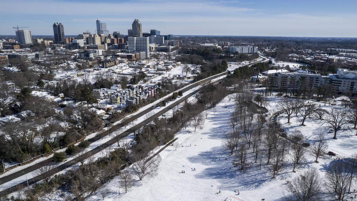 An aerial view shows snow covering much of downtown Raleigh on Sunday morning, Feb. 1, 2026. Raleigh’s Dix Park is at right.