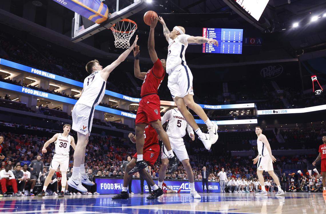 N.C. State's Ven-Allen Lubin (22) shoots while defended by Virginia's Jacari White (6) and Johann Grünloh (17) during Virginia’s 81-74 victory over N.C. State in the quarterfinals of the 2026 ACC Men’s Basketball Tournament at the Spectrum Center in Charlotte, N.C., Thursday, March 12, 2026.