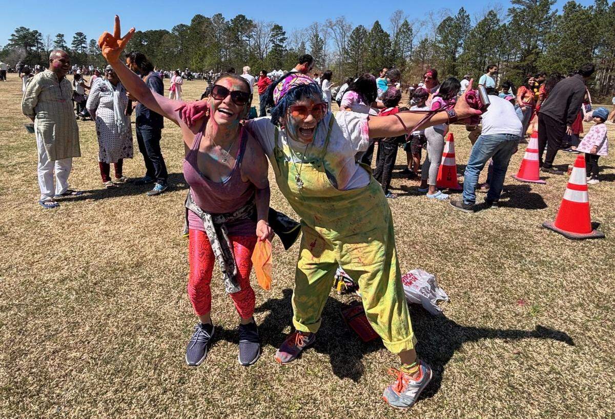 Friends Maria Williams (left) and Sandra Herrera, both of Raleigh, celebrate Holi at Morrisville’s 4th annual festival Saturday.