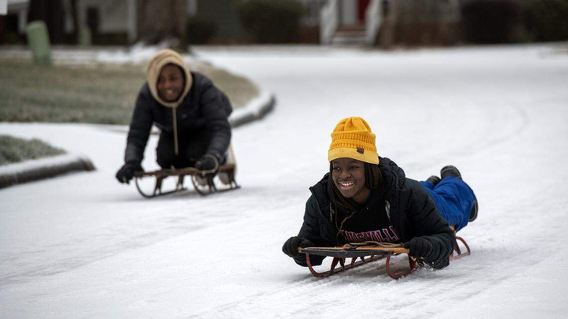 Addie Harman, left, 14, and John Mark Harman, 16, sled down Laketree Drive in North Raleigh Sunday, Jan. 25, 2026.