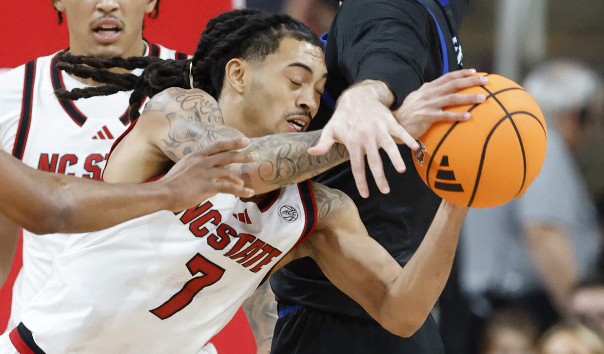 N.C. State's Alyn Breed (7) pulls in the rebound from UNC Asheville's David Hermes (23) during the first half of N.C. State’s game against UNC Asheville at the Lenovo Center in Raleigh, N.C., Saturday, Dec. 6, 2025.
