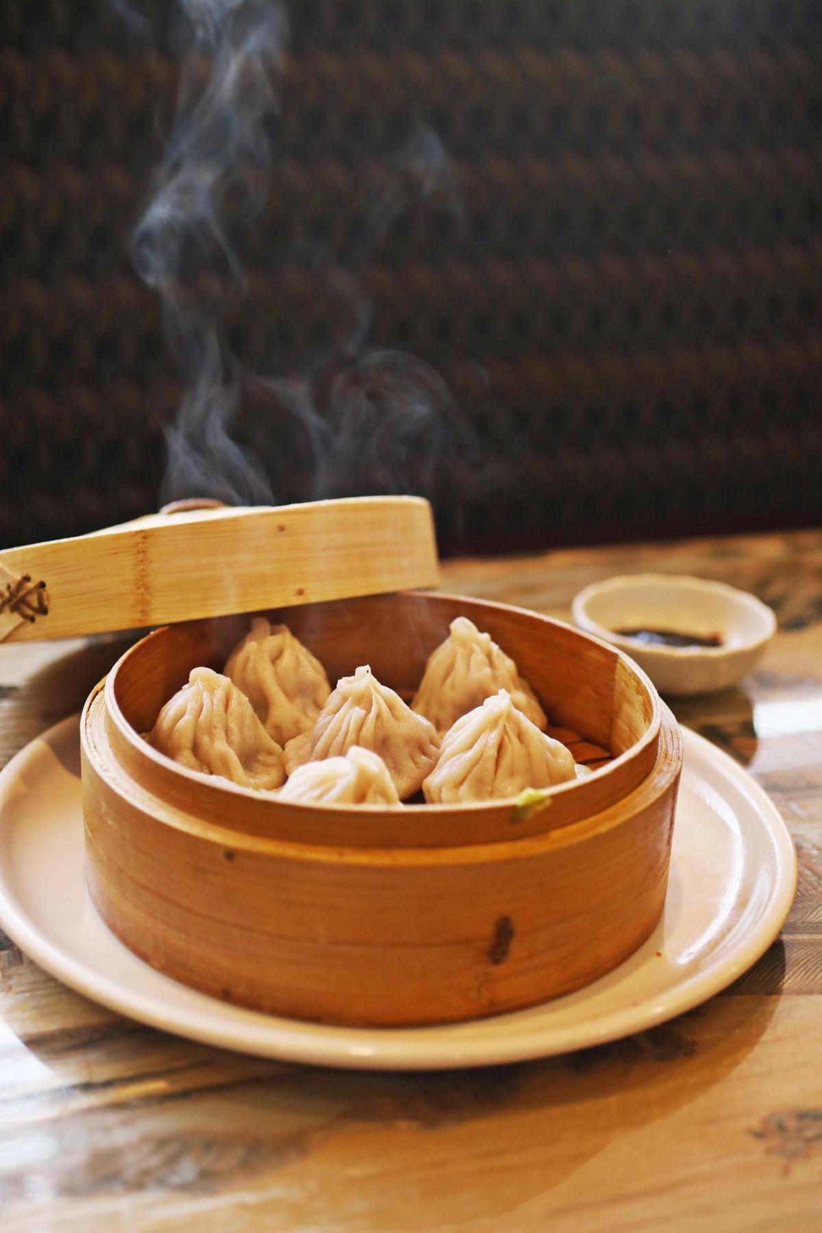 Steam rises off the Òsteamed Shanghai tiny bunÓ - pinch-topped purses of dumpling with a soupy minced pork and vegetable filling - at Yi Ge Asian Cuisine in Clayton.