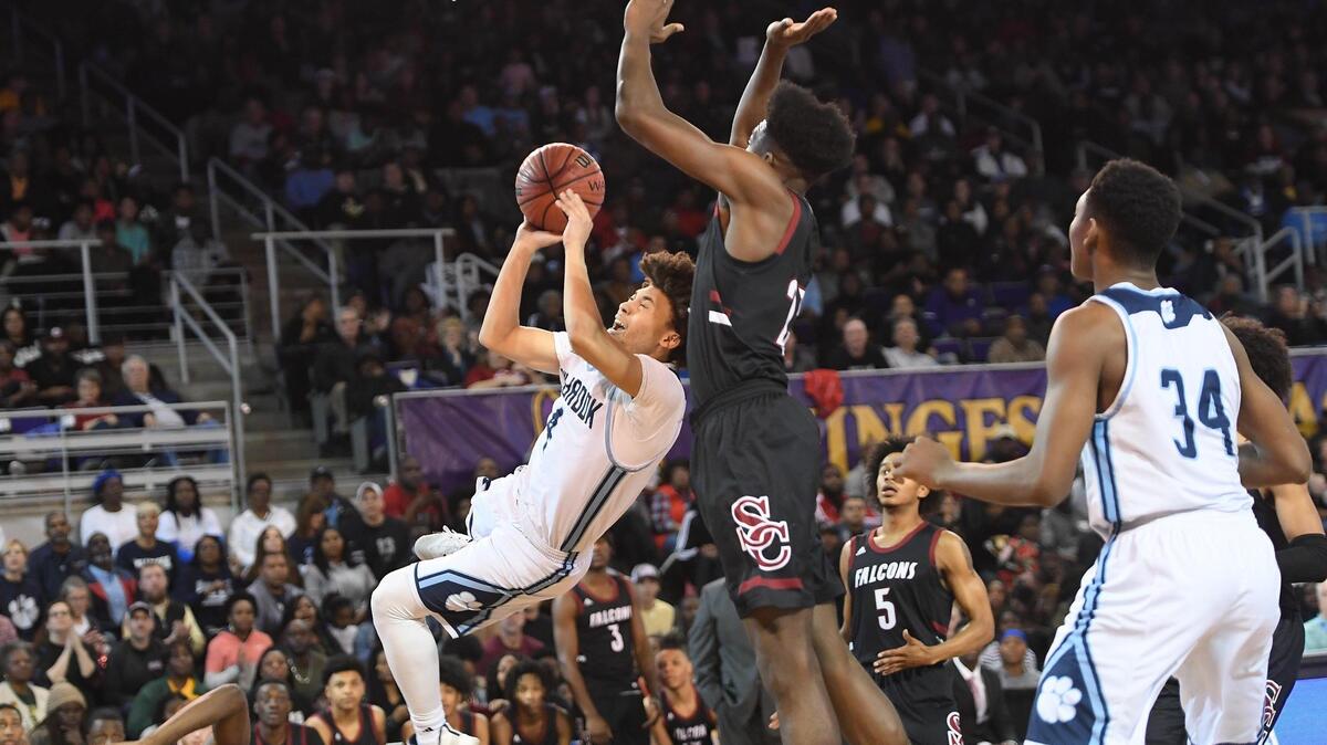 Collin Lewis (4) of Millbrook drives to the basket against Day’ron Sharpe (23) of South Central. The Millbrook Wildcats played the South Central Falcons in a high school men basketball game on March 9, 2019.