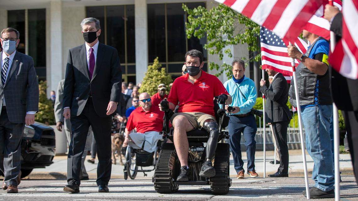 House Speaker Tim Moore and North Carolina Governor Roy Cooper cross Jones Street with Sgt. Michael Verardo as they make their was to a North Carolina Wounded Heroes Day Celebration on the Bicentennial Mall on Wednesday, April 21, 2021 in Raleigh, NC. Verardo survived wounds sustained during his service in Afghanistan.