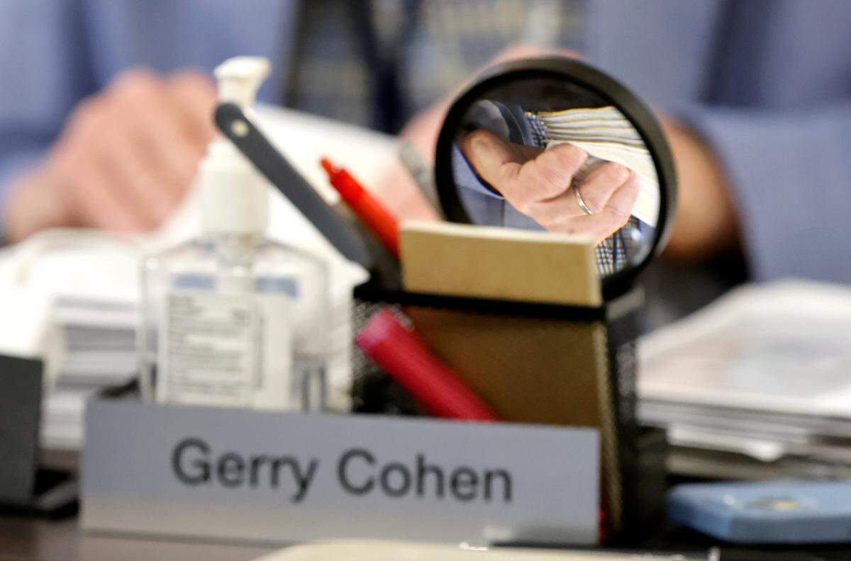 Wake County Board of Elections member Gerry Cohen inspects an absentee ballot during a board meeting at the Wake County Board of Elections Operations Center in Raleigh, N.C., Tuesday, Oct. 8, 2024.