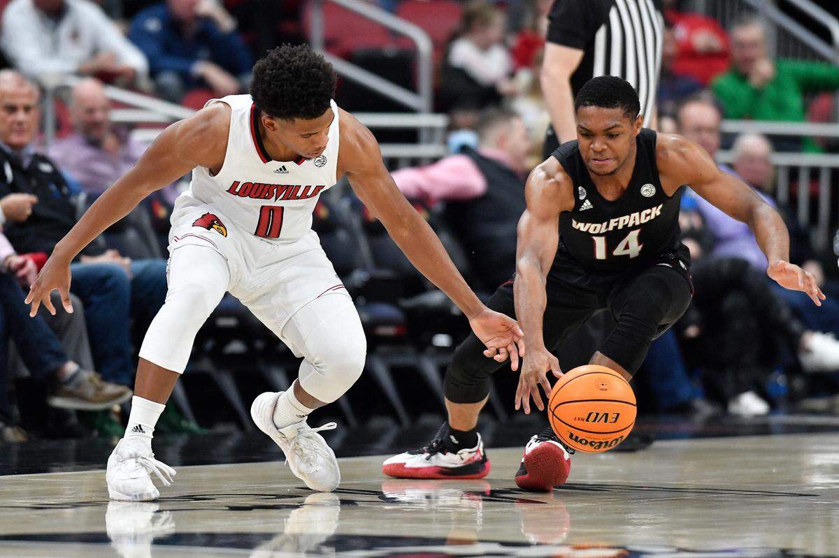 North Carolina State guard Casey Morsell (14) taps the ball away from Louisville guard Noah Locke (0) during the first half of an NCAA college basketball game in Louisville, Ky., Wednesday, Jan. 12, 2022. (AP Photo/Timothy D. Easley)