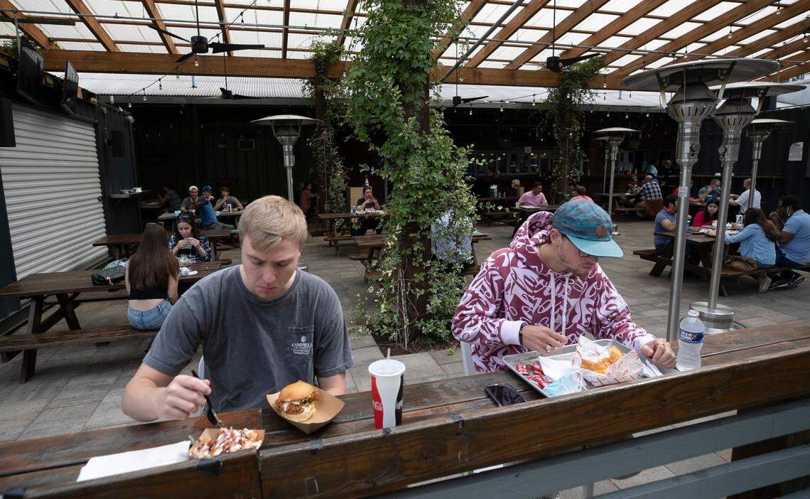 Joseph Riddle, left and Mason Meredith enjoy lunch outside at the Morgan Street Food Hall on West Street on Friday, October 9, 2020 in Raleigh, N.C.