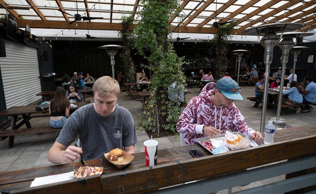 Joseph Riddle, left and Mason Meredith enjoy lunch outside at the Morgan Street Food Hall on West Street on Friday, October 9, 2020 in Raleigh, N.C.