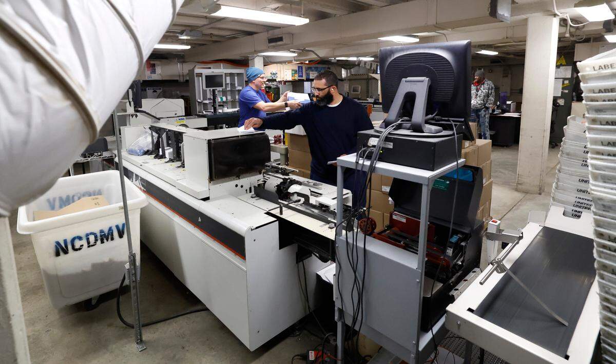 Jesse Davis, left, and James White work in the mailroom in the old DMV building on New Bern Ave. in Raleigh on Jan. 3, 2023. More than three years after the N.C. Division of Motor Vehicles moved its headquarters from Raleigh to Rocky Mount, seven employees still work in the agency’s mailroom.