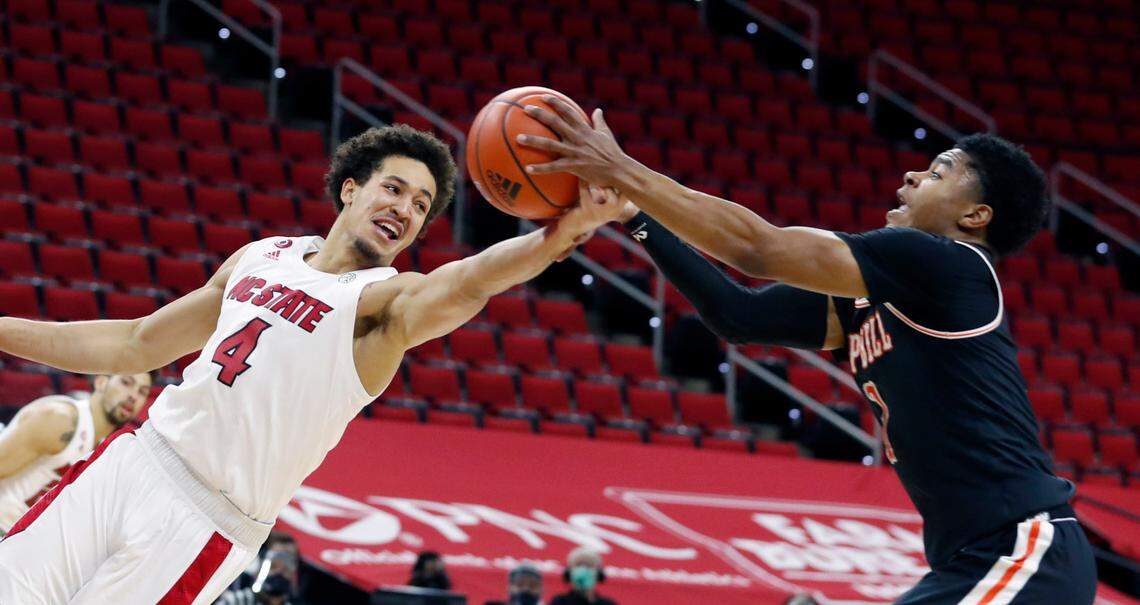 N.C. State’s Jericole Hellems (4) and Campbell’s Ricky Clemons (1) go after the rebound during the first half of N.C. State’s game against Campbell at PNC Arena in Raleigh, N.C., Saturday, Dec. 19, 2020.