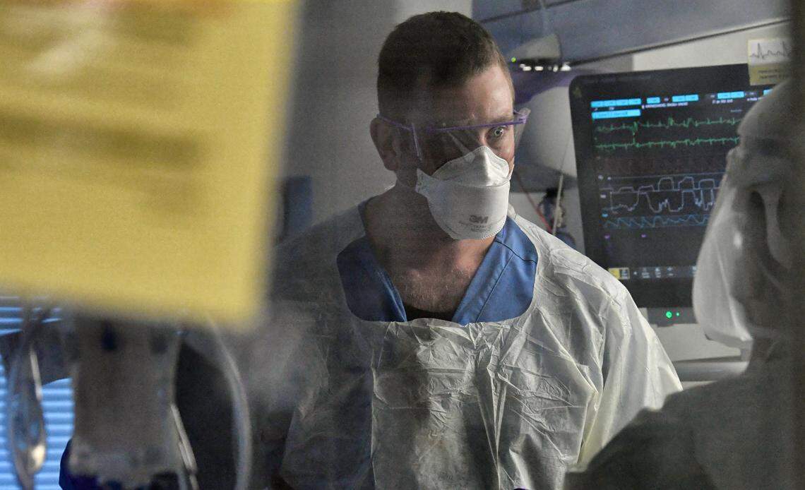 Registered nurse Dylan Lanphere works with a COVID patient on an ECMO machine in the Surgical Trauma ICU at UNC Hospital in Chapel Hill, N.C., Thursday, January 27, 2022.