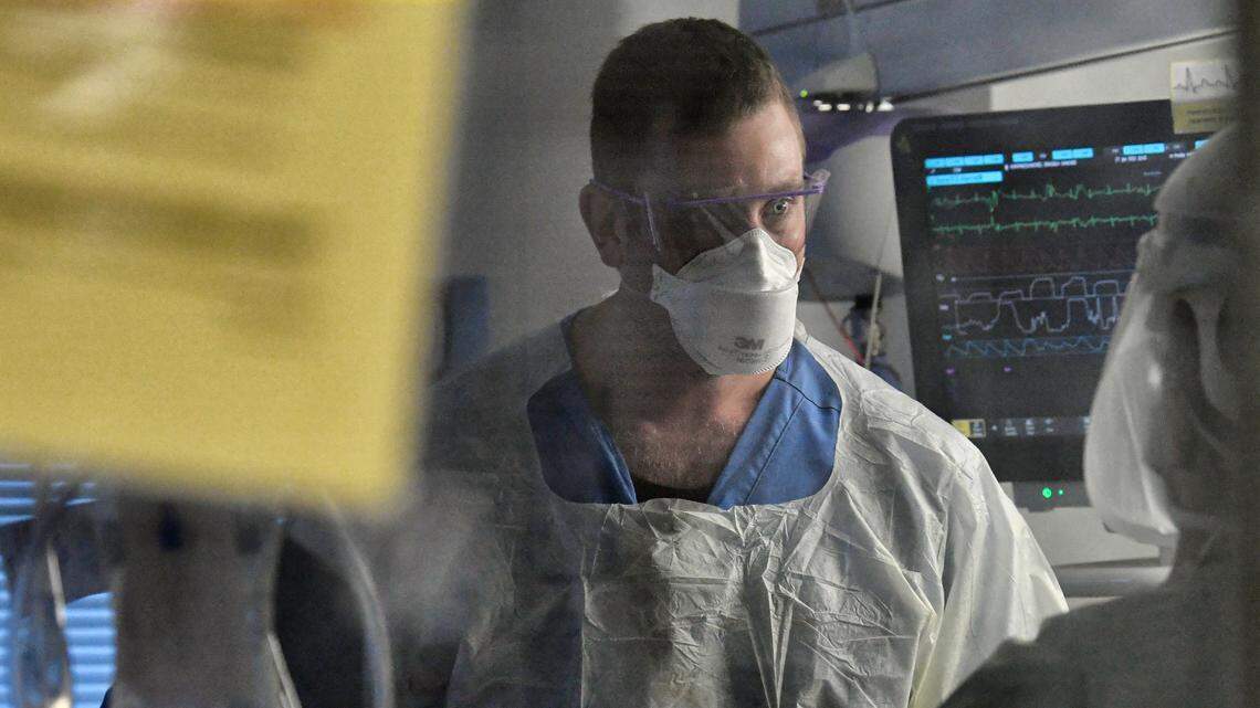 Registered nurse Dylan Lanphere works with a COVID patient on an ECMO machine in the Surgical Trauma ICU at UNC Hospital in Chapel Hill, N.C., Thursday, January 27, 2022.
