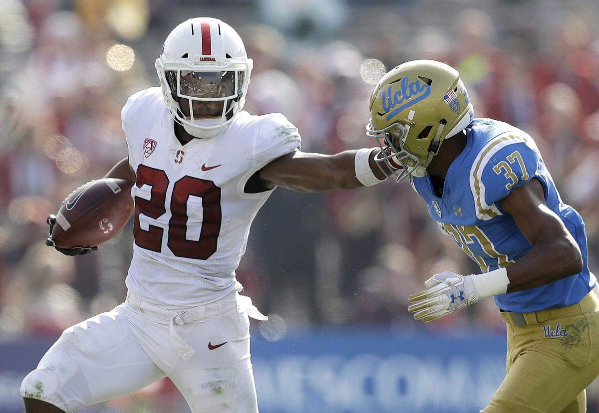 Stanford running back Bryce Love (20) stiff-arms UCLA defensive back Quentin Lake (37) during the first half of an NCAA college football game Saturday, Nov. 24, 2018, in Pasadena, Calif.