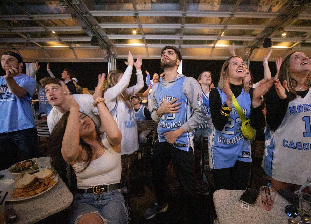 Tar Heel fans react to watching the first few plays of their team’s historic Final Four game against their rival, the Duke Blue Devils, at Top of the Hill in Chapel Hill, N.C. on Saturday, April 2, 2022.