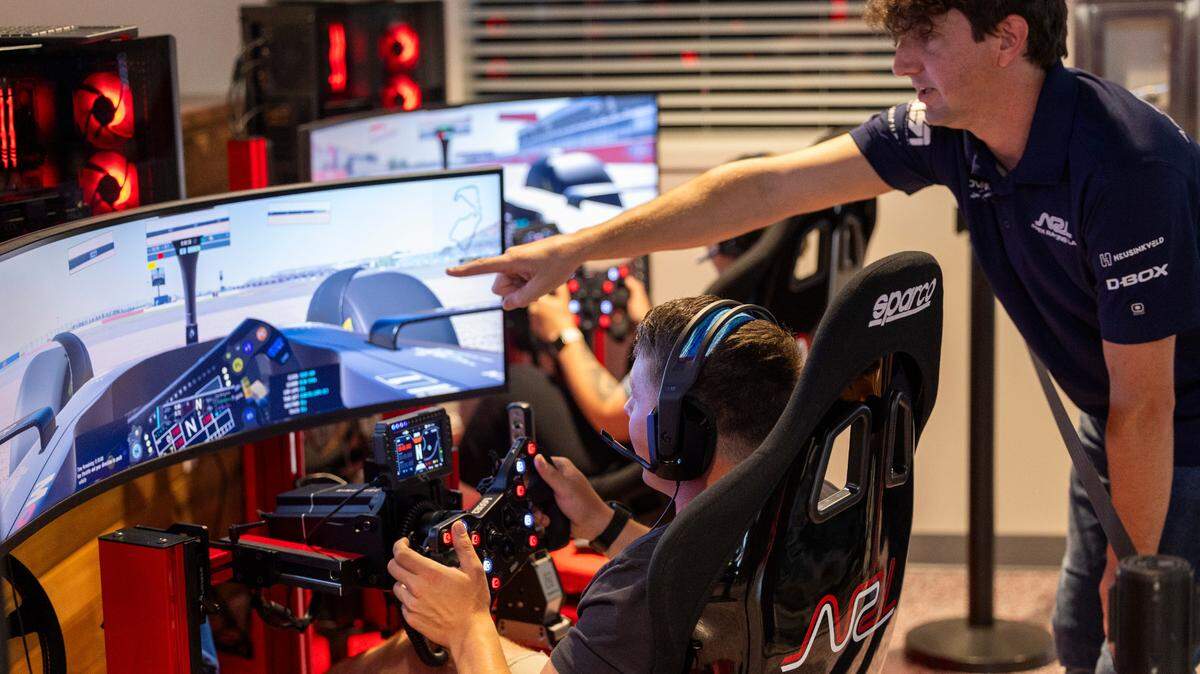 Adam Perrell helps guide Maverick Bostic and Ashlee Salazar during a racing simulation at Apex Racing Lab on Saturday, July, 13, 2024. The business features 16 racing simulators, a conference room, a craft cocktail bar and a gear shop, selling racing equipment.