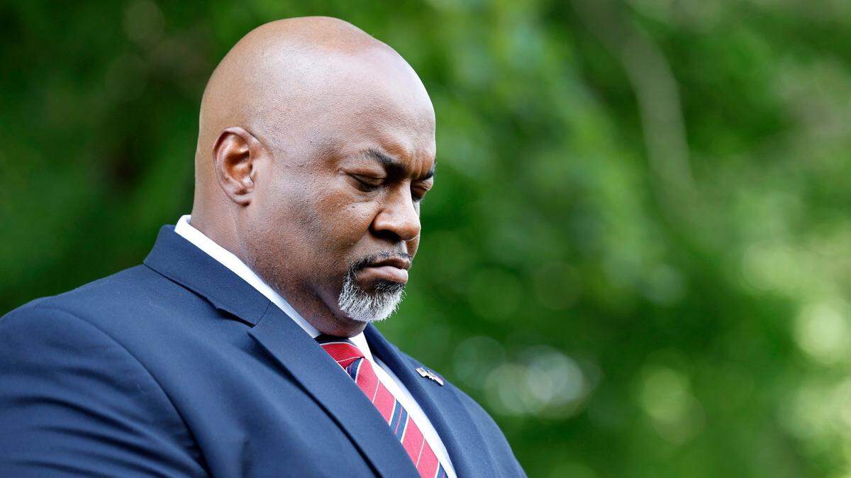 Lt. Gov. Mark Robinson bows his head during the opening prayer at a Moms for Liberty rally outside the Legislative Building in Raleigh, N.C., Wednesday, June 12, 2024.